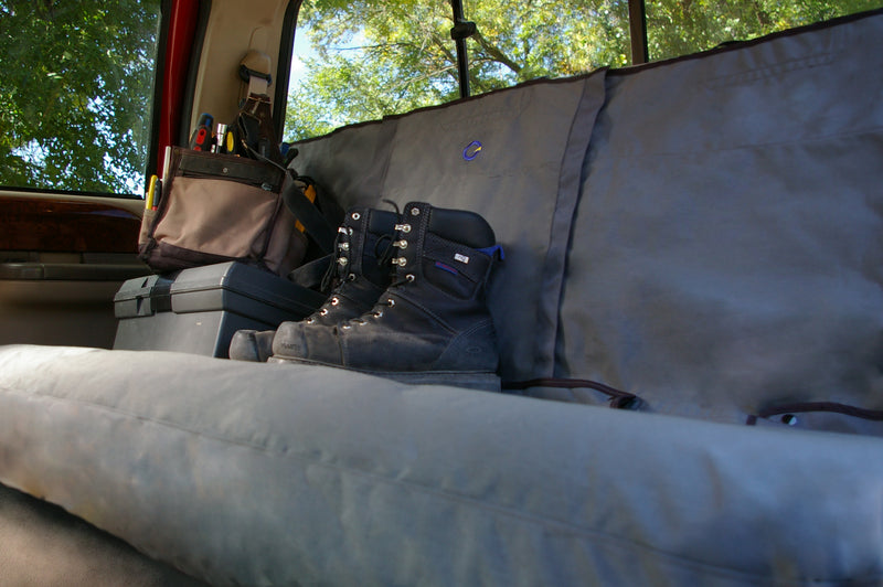 Bench rear seat cover in work truck protected from tools and dirty boots placed on the seat